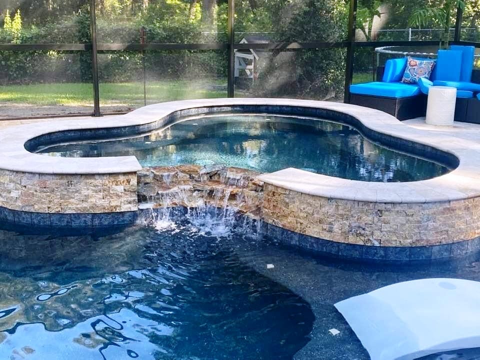 A pool with water falling into it and a blue chair.