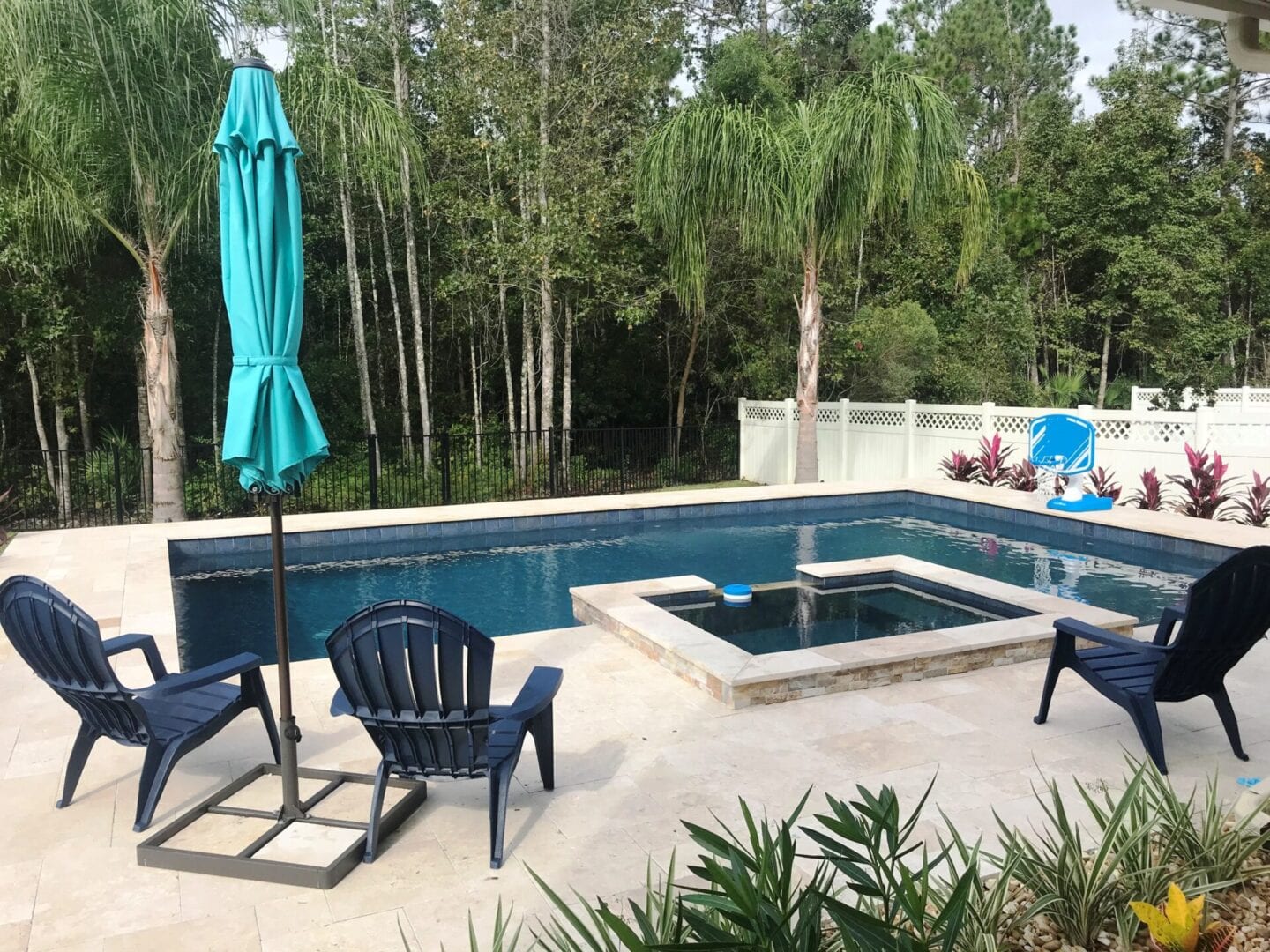 A pool with chairs and an umbrella in the middle of it.