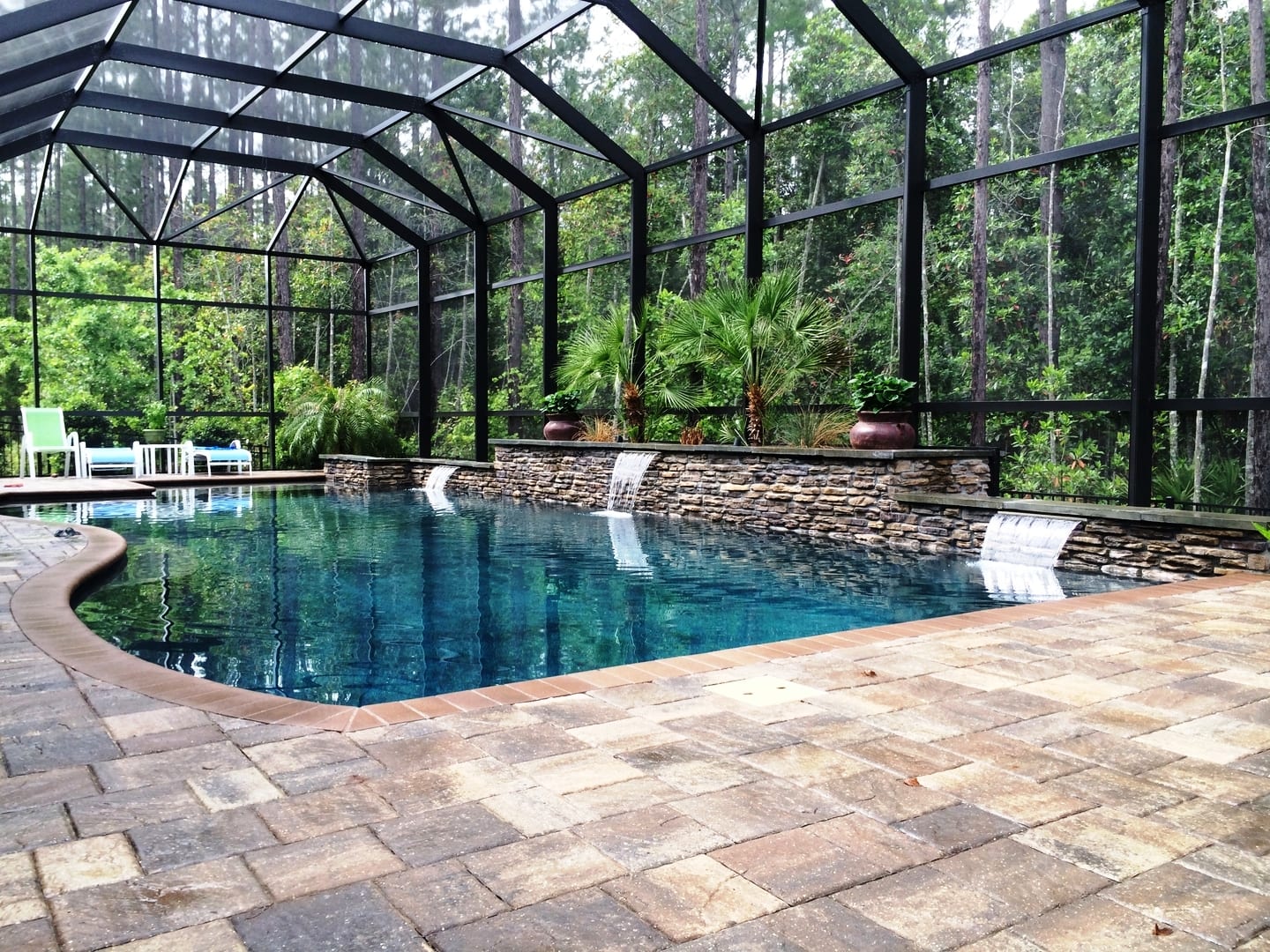 A pool with a stone floor and a glass roof