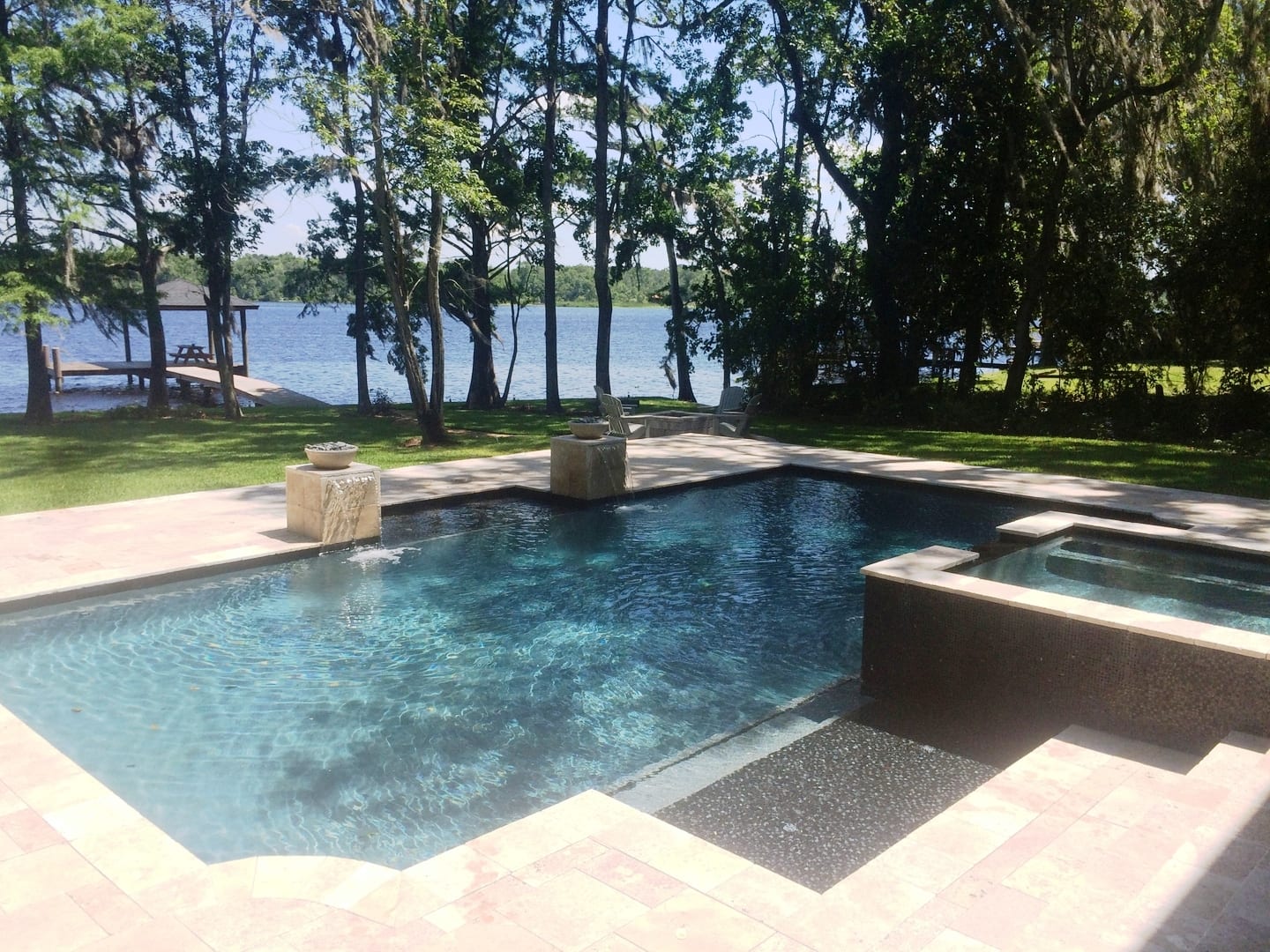 A pool with a view of the water and trees.